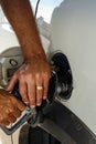 A man pumping gasoline into his vehicle's gas tank