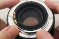 A man holding an old camera lens with dust on it in his hands Royalty Free Stock Photo