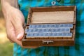 Man holding an old fashioned retro wooden box full of movable type rubber stamp alphabet letters Classic font letter set closeup Royalty Free Stock Photo