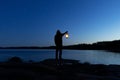 Man holding the old lamp outdoors near the lake. Hand holds a large lamp in the dark. Royalty Free Stock Photo