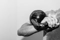 Man holding old and rusty kettle bell on his shoulder. Royalty Free Stock Photo