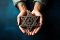 A man holding an old and rusty star of David in their hands on ruins background. Royalty Free Stock Photo