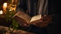 A man holding an open bible in front of a candle, AI Royalty Free Stock Photo