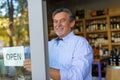 Man holding open sign in wine shop