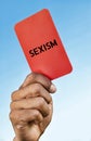 Man holding out a Sexism red card