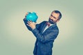 Man holding overturned piggy bank, showing its emptiness Royalty Free Stock Photo