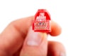 Man holding an 8P8C RJ-45 crimped red ethernet connector, unshielded twisted pair UTP straight through cable end, macro, detail