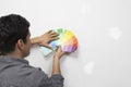 Man Holding Paint Color Samples Against Wall