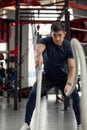 Man holding a pair of battle ropes for workout. guy at the gym working out with fitness rope.