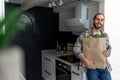 Man holding paper grocery shopping bag full of fresh healthy food vegetables in his hand. Royalty Free Stock Photo