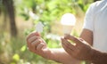 Man holding paper house and light bulb in nature Royalty Free Stock Photo