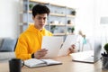 Man holding paper reading report working on laptop at home Royalty Free Stock Photo