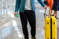 Man holding passport and luggage in his hand large yellow suitcase at airport. Man at the check-in counter at airport Royalty Free Stock Photo