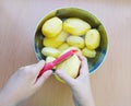 Close up of man holding and peeling potato. Hands cutting potatoes at kitchen to prepare a recipe