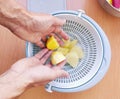 Close up of man holding and peeling potato. Hands cutting potatoes at kitchen to prepare a recipe