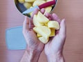 Close up of man holding and peeling potato. Hands cutting potatoes at kitchen to prepare a recipe