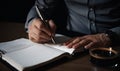 Man holding a pen above the paper notebook. Businessman taking notes. Close up. Generative AI Royalty Free Stock Photo