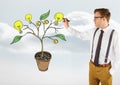 Man holding pen and Drawing of Money and idea graphics on plant branches on wall