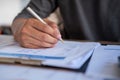 Man holding pen to point in paperwork, meeting concept