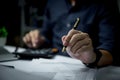 man holding pen with writing on paper report or signature law, contract at desk Royalty Free Stock Photo