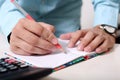 Man holding pencil in hand with notebook and calculator on the table Royalty Free Stock Photo