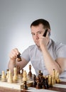 Man holding a phone in their hands and playing chess Royalty Free Stock Photo