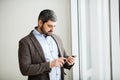 Man holding phone - young businessman using smartphone in office Royalty Free Stock Photo