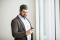 Man holding phone - young businessman using smartphone in office Royalty Free Stock Photo