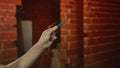 Man holding picklock in indoor construction setting with red brick walls, showcasing tool with focus on hand and craftsmanship Royalty Free Stock Photo
