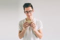 Man holding a piece of hamburger. student eats fast food. not helpful food. very hungry man. Nerd is wearing glasses. Royalty Free Stock Photo