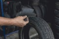 A man holding a piece of rubber to be used to patch the punctured inner liner of a tire. Vulcanizing procedure