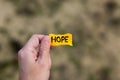 Man holding piece of yellow paper with the word Hope in his hand Royalty Free Stock Photo