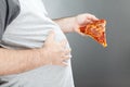 Man holding pizza and rubbing his belly