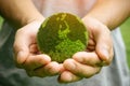 man holding planet in hands against green spring background. Earth day concept. Royalty Free Stock Photo