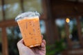 Man holding a plastic cup of iced Thai milk tea Royalty Free Stock Photo