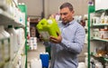 Man holding plastic gallon in hypermarket