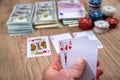 Man holding play card. poker chips, us dollar