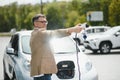 Man holding power connector for electric car Royalty Free Stock Photo