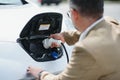 Man holding power connector for electric car Royalty Free Stock Photo