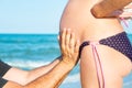 A man is holding a pregnant woman by the stomach on the beach, by the sea. The concept of family, love, new life and peace, the ex Royalty Free Stock Photo