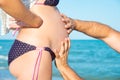 A man is holding a pregnant woman by the stomach on the beach, by the sea. The concept of family, love, new life and peace, the ex Royalty Free Stock Photo