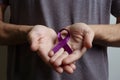 Man holding purple ribbon