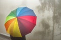 Rainbow colored umbrella on foggy rainy day in autumn Royalty Free Stock Photo