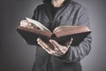 Man holding reading holy bible with gray background Royalty Free Stock Photo