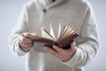 Man holding reading open holy bible or book with gray background Royalty Free Stock Photo