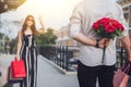 Man holding a red flower behind his back to surprise your lover