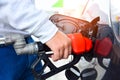 Man holding red fueling nozzle and pumping gasoline fuel fill in car at gas station, car fuels or transportation concept Royalty Free Stock Photo