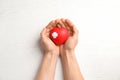 Man holding red heart with adhesive plasters on wooden background, top view. Royalty Free Stock Photo