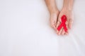 Man holding Red Ribbon for supporting people living and illness. Healthcare and safe sex concept. December World Aids Day