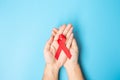 Man holding Red Ribbon for supporting people living and illness. Healthcare and safe sex concept. December World Aids Day